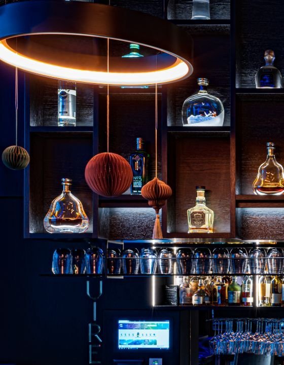 Die Bar mit Kupfer-Ringleuchte und edlen Spirituosen